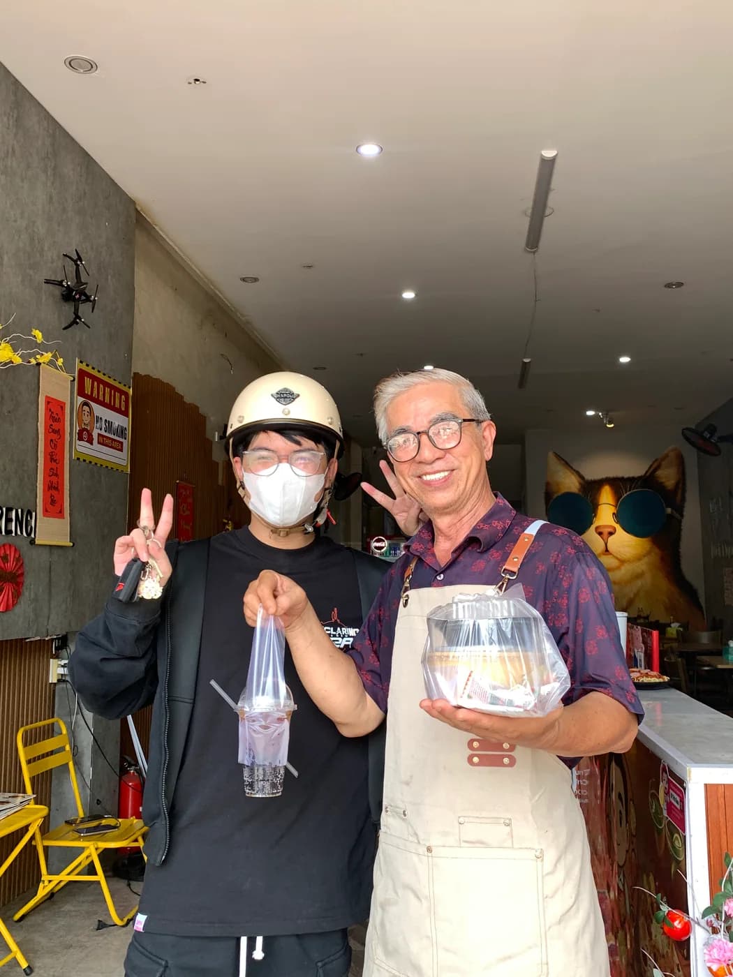 Ông Trọng giao món và nước cho khách hàng tại cửa hàng